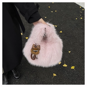 Dettaglio della borsa a secchiello rosa peluche con fiocco leopardato e ciondolo morbido