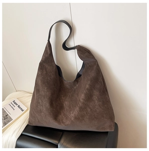 Macro detail of dark brown matte suede texture and slouchy silhouette on large tote bag