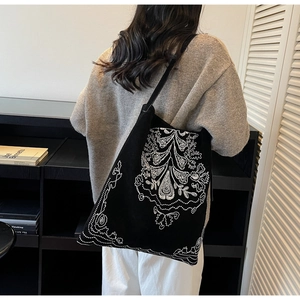 Detail der schwarzen Shopper-Tasche mit weißer Ethno-Stickerei auf Wildlederimitat