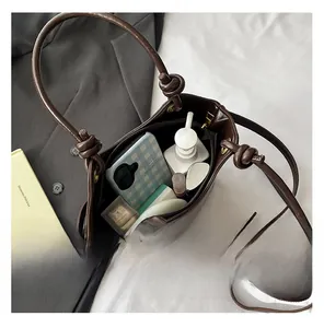 Macro view showing large capacity of coffee brown leather bucket bag with daily items