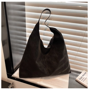 Macro detail of black matte suede tote bag with artistic window shutter shadow lighting