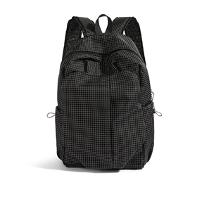 Detail of black grid nylon backpack featuring side drawstring pockets and durable handles