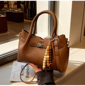 Détail du sac seau marron vintage avec perles en bois arc-en-ciel et fermoir rotatif en métal