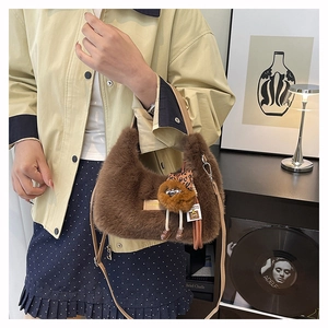 Detailed view of plush faux fur hobo bag with teddy charm and leather straps