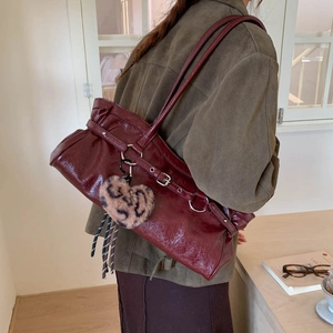 Détail du sac bandoulière plissé bordeaux brillant avec breloque cœur léopard