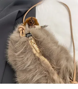 Close-up of fluffy faux fur texture and gold metal zipper on brown plush crossbody bag