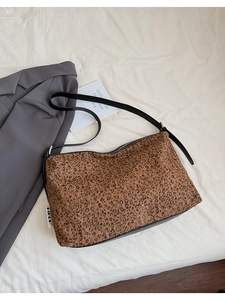 Détail du sac cabas léopard avec bandoulière en cuir noir et finition en tissu texturé