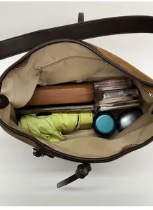 Top view of spacious brown suede tote bag showing interior storage with daily essentials