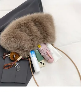 Macro shot of spacious brown plush shoulder bag interior with plush bear charm and items