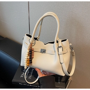 Sac seau blanc cassé en cuir grainé avec un pendentif décoratif en perles