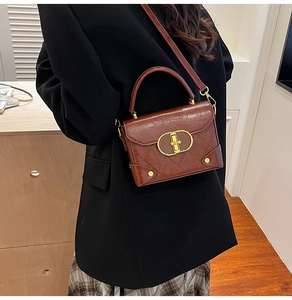 Detail view of retro crossbody bag with quilted pattern and golden buckle worn by a model