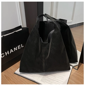 Close-up of black matte hobo tote bag with a minimalist design on a wooden table