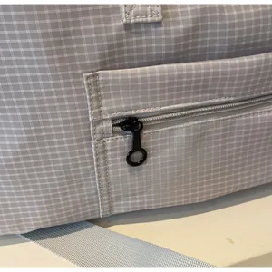 Detailansicht der grauen Reisetasche mit rundem Reißverschluss und Nylon-Schultergurt