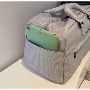 Makroaufnahme der Seitentasche einer grauen Reisetasche mit Tablet zur Aufbewahrung