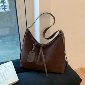 Detail of vintage matte leather tote bag with leather tag and decorative drawstring