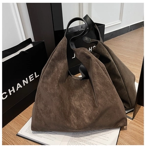 Detailed mirror view of a large dark brown suede hobo bag with a wide black shoulder strap