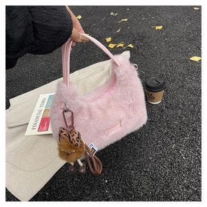 Pink plush tote bag detail with teddy bear charm and soft faux fur texture close-up