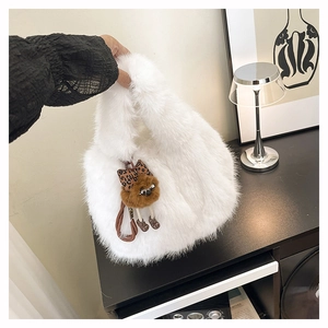 Dettaglio borsa a secchiello in peluche bianco con ciondolo orsetto leopardato in interno