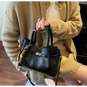 Détails du sac seau en cuir grainé noir avec boucle argentée et pendentif à perles