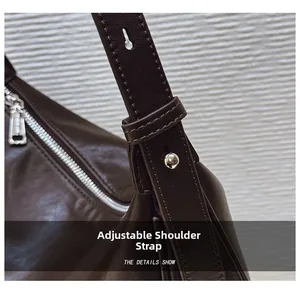 Close-up of dark brown leather crossbody bag featuring adjustable shoulder strap with silver buckle