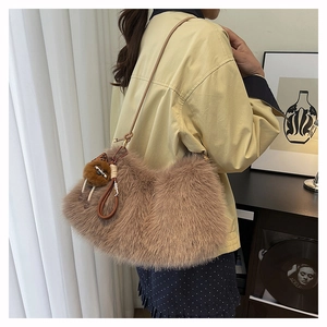 Detail view of dark brown plush dumpling bag with a soft faux fur finish and cartoon charm