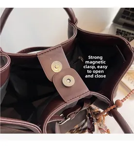 Detail view of tote bag with magnetic closure, inner zipper pocket and wood bead charm