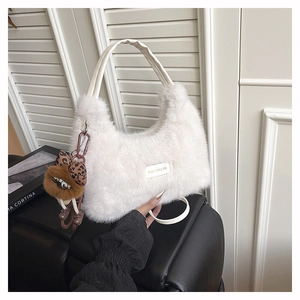 Close-up of white faux fur bag with love every day tag and cute animal charm accessory