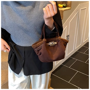 Close-up of brown suede bucket bag with faux fur trim and silver metallic buckle detail