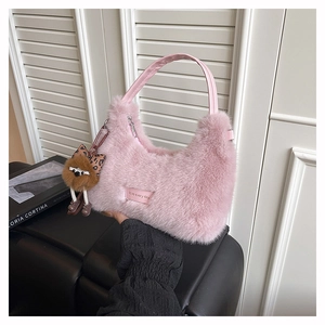 Detail of pink faux fur handbag with leather handles and cute plush doll pendant