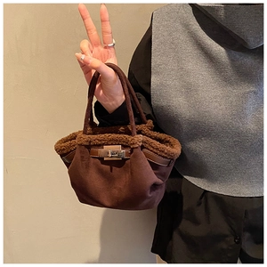 Detail of dark brown suede bucket bag with faux fur trim and silver turn-lock closure