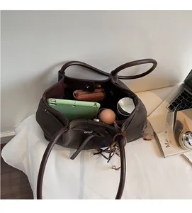 Top view of spacious interior in retro dark brown tote bag holding tablet and wallet