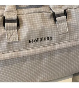 Detailansicht der hellgrauen Reisetasche mit Weilaibag-Logo und robuster Schnalle