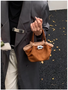 Detail of caramel suede mini tote featuring beige faux fur trim and silver metal twist lock