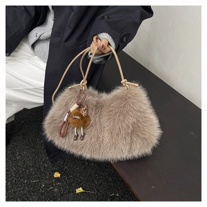 Close-up of fluffy faux fur handbag with leather knot handle and doll charm accessory