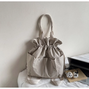 Detail of drawstring bucket bag with dual front pockets and versatile backpack straps