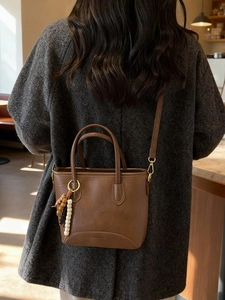 Vintage brown leather bucket bag with beaded charm on grey tweed coat fashion outfit