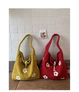 Detail of plush flower tote bag with white floral embroidery and wooden button closure