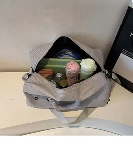 Detail der grauen Reisetasche mit Karomuster zeigt den geräumigen Innenraum und Stauraum