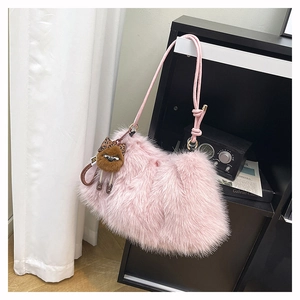 Detail of pink faux fur shoulder bag with textured rope strap and cute plush doll pendant