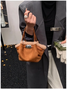 Close-up of caramel suede tote bag featuring plush faux shearling trim and silver metal lock