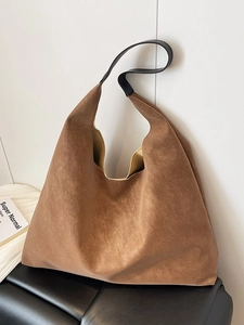 Vintage brown frosted faux suede tote bag with black handles on a minimalist chair