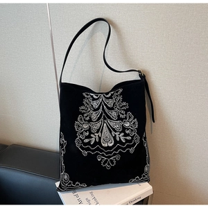 Detailansicht der großen schwarzen Wildledertasche mit weißer Ethno-Stickerei am Band