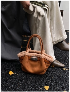 Detailed view of the brown suede tote bag with pink faux fur trim and silver metal twist lock
