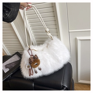 Close-up of white faux fur shoulder bag with plush animal charm and leopard bow