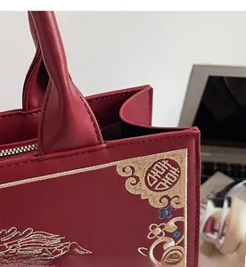 Detail of red Chinese embroidery on tote bag with reinforced stitching and dragon pattern