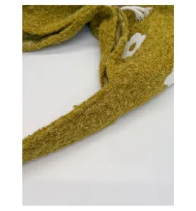 Detail of wide shoulder strap and mustard yellow plush faux fur texture with flower embroidery