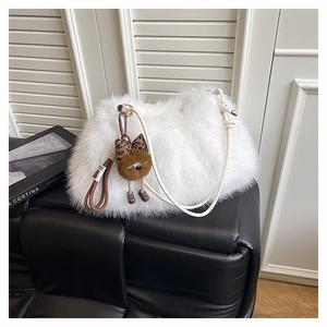 Detail of fluffy white plush hobo bag with teddy bear charm and soft cord shoulder straps