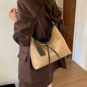 Detail view of large matte vintage hobo bag showing shoulder strap and brown leather trim