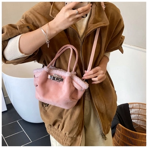Detail of pink suede tote bag with faux fur trim and silver turn-lock closure