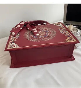 Detail of red bridal handbag featuring golden dragon phoenix embroidery and Xishi character